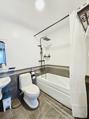 A bathroom with a toilet, sink, bathtub, shower, and a towel rack. - The Star Hotel - Phu My Hung (Ho Chi Minh City)