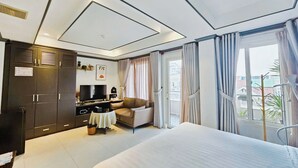 Una habitación de hotel moderna con una cama grande, un sofá, un televisor y un armario.