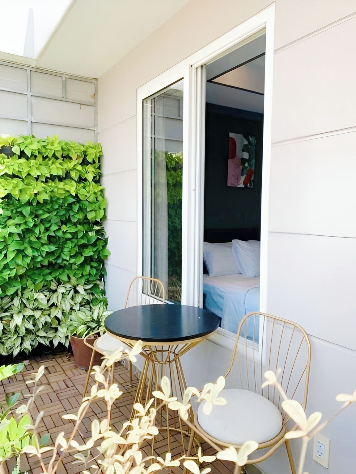 Una habitación con cama, ventana y una pequeña mesa con sillas.
