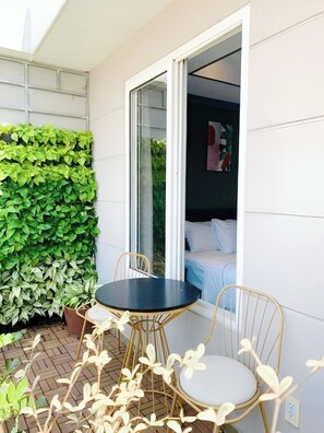 Une pièce avec un lit, une fenêtre et une petite table entourée de chaises.