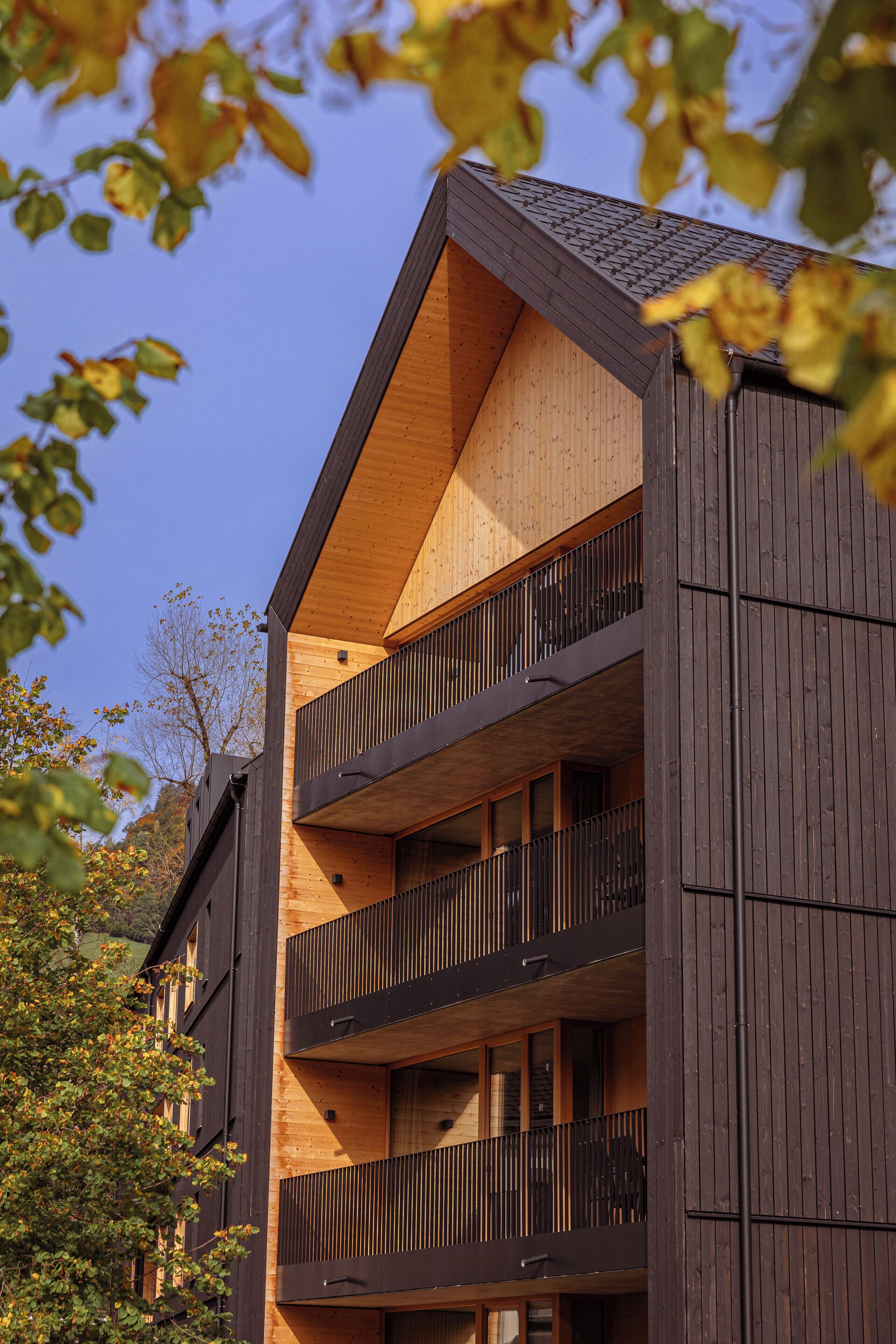 Ein mehrgeschossiges Gebäude mit Holzverkleidung und Balkonen.
