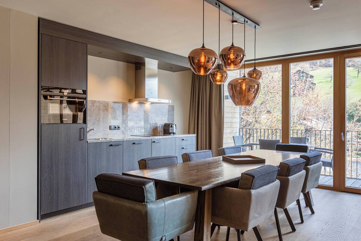 Una cocina moderna con comedor, ventanas amplias y vistas al exterior.