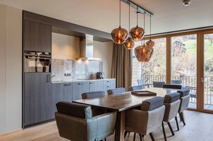 Una cocina moderna con comedor, ventanas amplias y vistas al exterior.