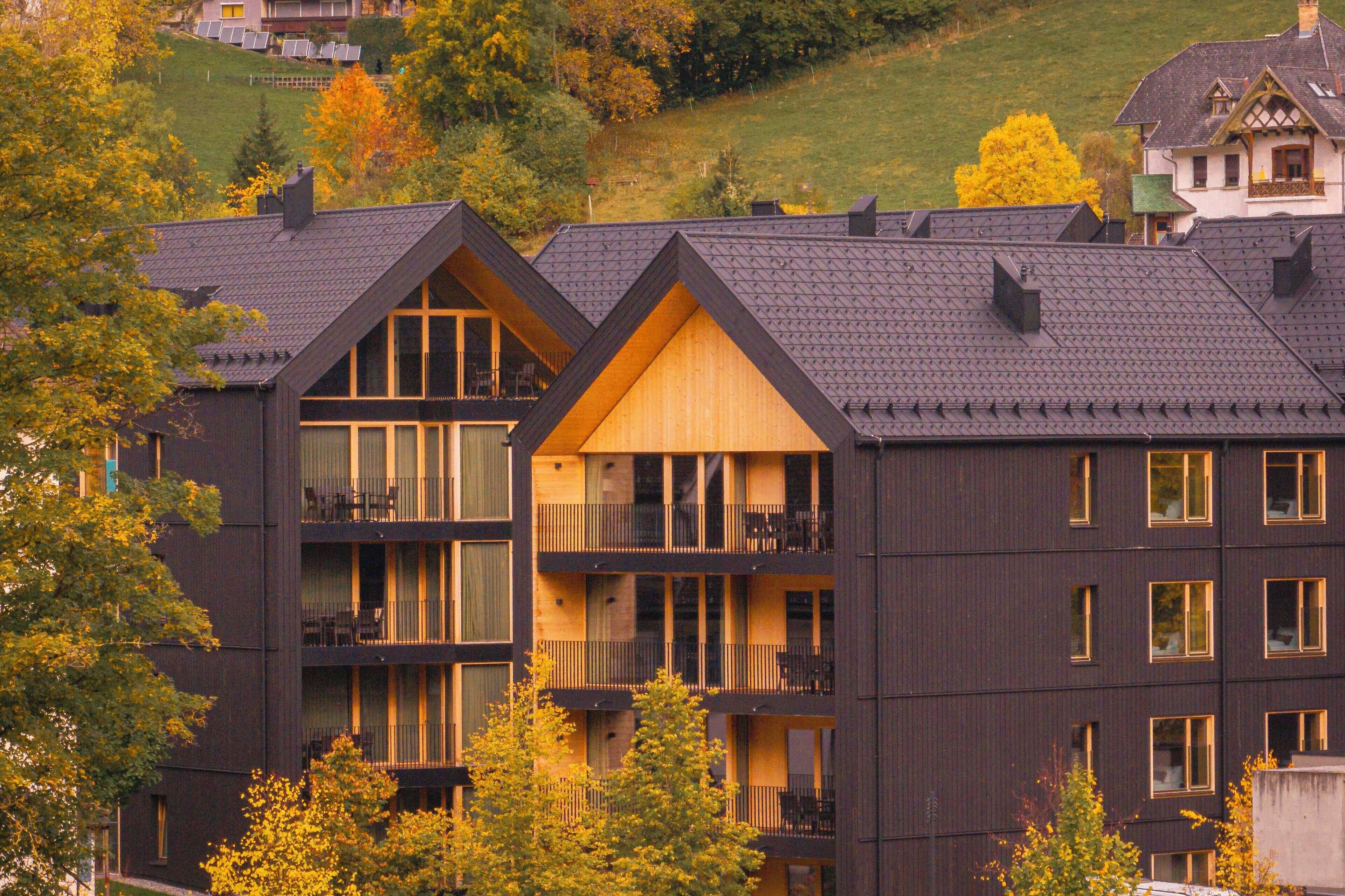 A multi-story building with balconies, large windows, and a dark exterior.