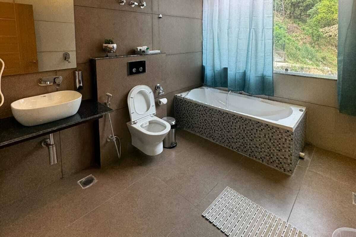 A modern bathroom with a large bathtub, a toilet, and a sink.