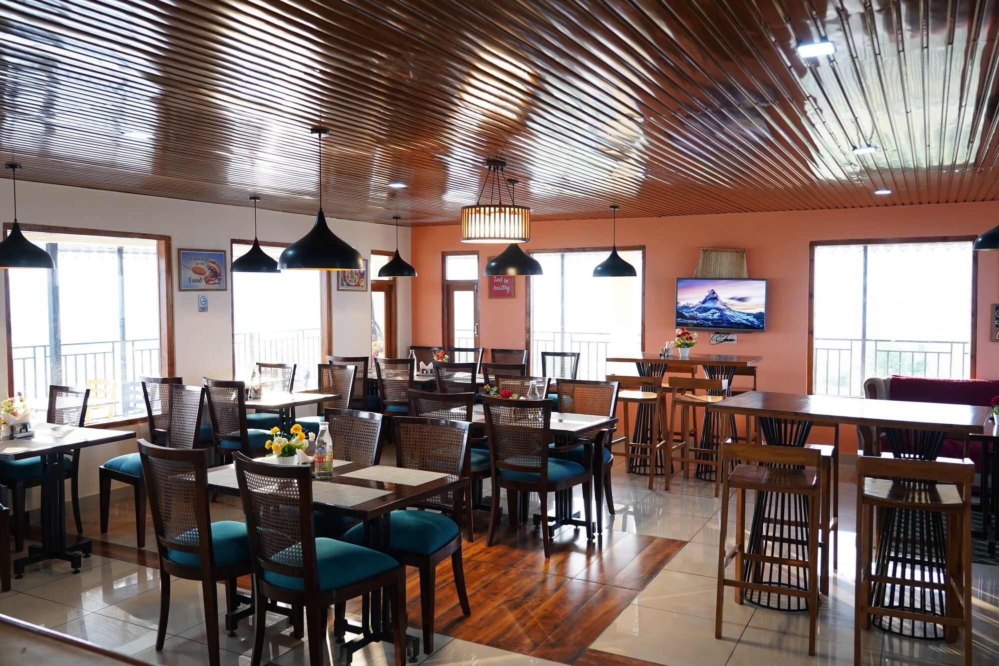 A restaurant with multiple dining areas, including a bar and booths. There are ceiling fans and pendant lights.