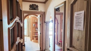 A wooden hallway with a bookshelf, a door with a notice, and a stone column. - Terrazzo Prato Pernice Apt.12 by Interhome (Orselina)