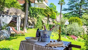 An outdoor dining area with a table set for two, featuring a bowl of snacks, a bottle of Corona beer, and a bottle of wine. - Ca`Sotselva by Interhome (Besazio)
