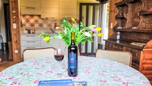 A dining table with a floral tablecloth, a bottle of wine, and a glass of red wine. There is a brochure on the table. - Ca`Sotselva by Interhome (Besazio)