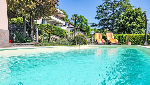 A clear blue pool with lounge chairs and a stone wall. - Ca`Sotselva by Interhome (Besazio)