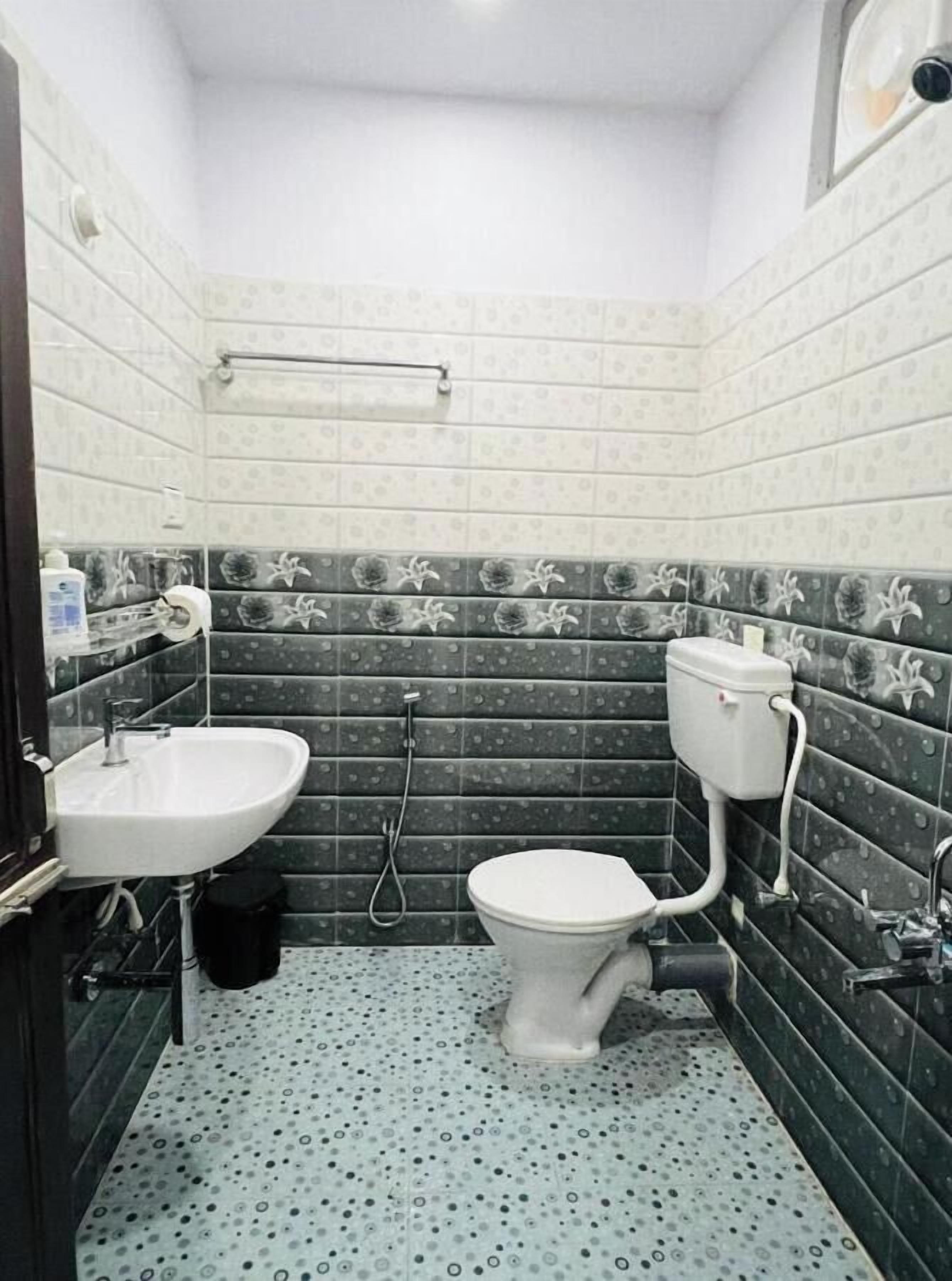 A small bathroom with a toilet, sink, and shower.