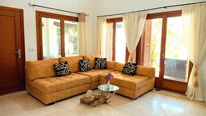 A living room with a brown sectional sofa, a glass coffee table, and a decorative wooden piece on the floor. - Lux Villa LONG-TERM RENT for 7 ppl, Private pool, Sauna, Tennis, Gym, Golf, swim (Baños y Mendigo)