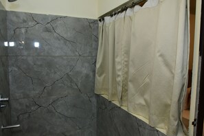 A bathroom with dark marble walls and a beige shower curtain. - Sai Vihaar Inn & Suites (Mysore)