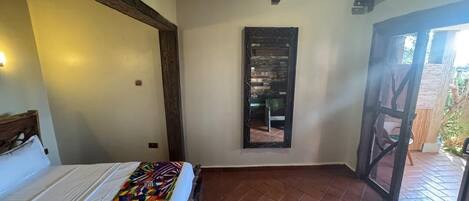 Una habitación con una cama, un ventanal pequeño y vistas al exterior.