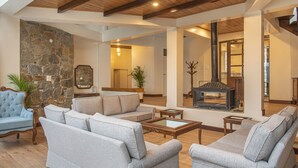 A spacious living room with a stone wall, a fireplace, and modern furniture.