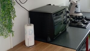 Et tekøkken med mikroovn, brødrister og gasblus.