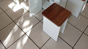 Et moderne bord med en træplade og matchende ben, samt to tilhørende barstole.