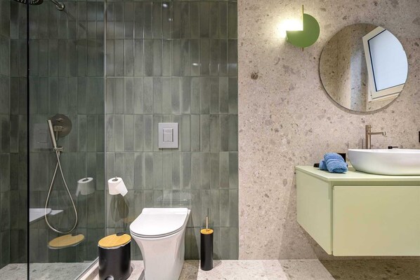 A bathroom with a shower, toilet, and sink.