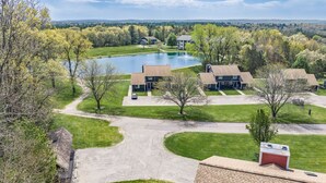 A residential area with houses, a pond, and a clear sky.