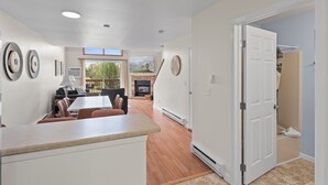 A spacious living area with a fireplace, a dining table, and a view of the outdoors.