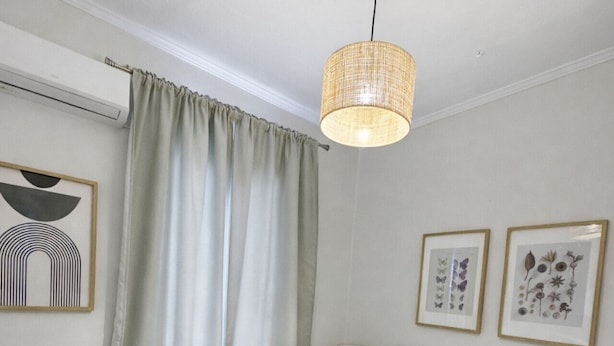 A hotel room with a bed, a hanging light fixture, a window with curtains, and framed botanical prints on the wall. - Classic Comfort in the Heart of Monastiraki | Walk to the Acropolis, Agora & More (Athina)