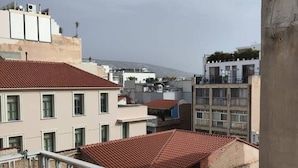 A residential building with a red-tiled roof, white railings, and multiple windows. - Classic Comfort in the Heart of Monastiraki | Walk to the Acropolis, Agora & More (Athina)