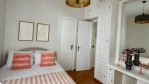 A bedroom with a bed, a large mirror, and a wardrobe. - Elegant Kolonaki Retreat | Sophisticated 2-Bedroom Apartment in Upscale Central Athens (Athina)