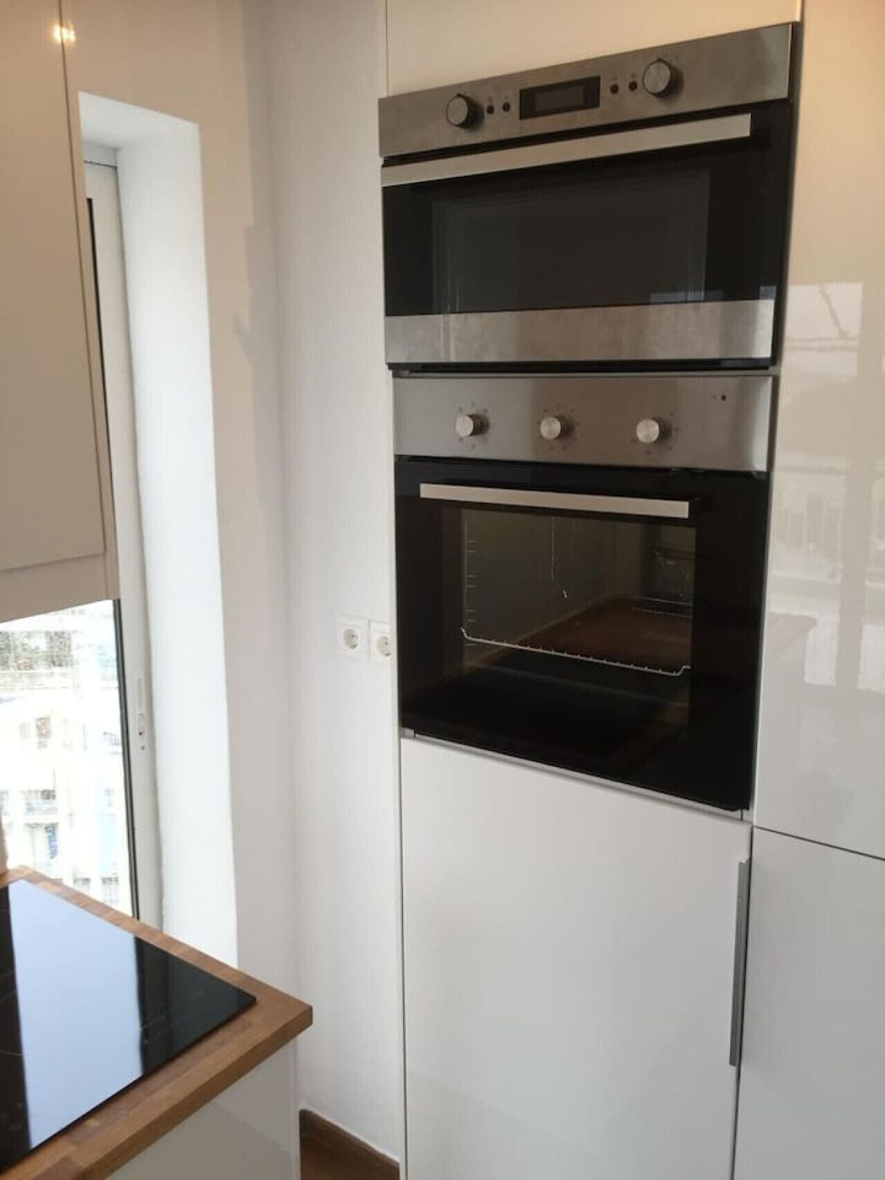 A modern kitchen with a built-in oven and a microwave.