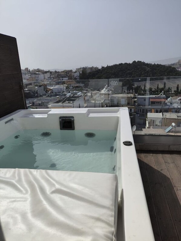 Una piscina en la azotea con vistas despejadas del paisaje urbano y colinas al fondo.