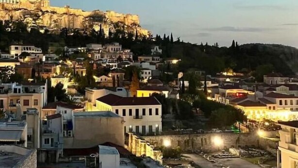 A cityscape with a prominent ancient citadel on a hill, surrounded by residential buildings. - Acropolis View Penthouse | Panoramic Terrace in the Heart of Athens (Athina)