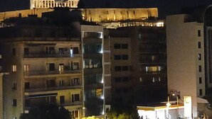 A multi-story building with balconies and windows, illuminated at night.