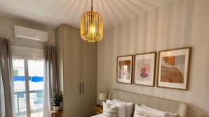 Une chambre spacieuse avec un grand lit, un luminaire suspendu et un balcon offrant une vue agréable.