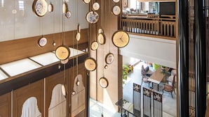 Un intérieur japonais traditionnel avec des lambris en bois, un plafond décoratif et une vue sur une salle à manger située en contrebas.