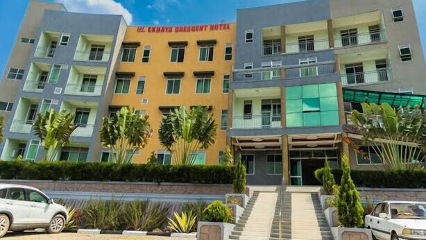 A multi-story hotel with a central entrance, balconies on each floor, and a parking area in front. - Ekhaya crescent hotel mbarara (Mbarara)