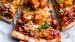 A pizza with chicken, cheese, and red onions. - Ekhaya crescent hotel mbarara (Mbarara)