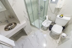 A modern bathroom with a glass-enclosed shower, a bidet, a toilet, and a sink with a metal basin. - Flexible Studio for 4 with Balcony in Palermo Soho (Palermo)