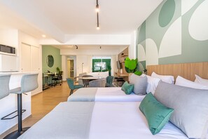 A modern hotel room with two beds, a dining area, and a view of the outdoors. - Flexible Studio for 4 with Balcony in Palermo Soho (Palermo)