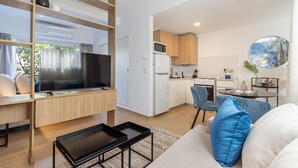 A modern apartment with a living area, kitchen, and dining space.