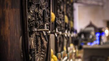 A row of beer taps with ornate carvings on the wall.