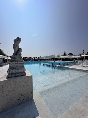 Una piscina al aire libre de temporada, sombrillas