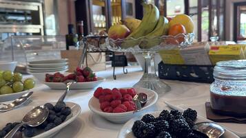 A buffet table with various fruits and a glass display case.