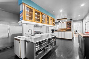 Una cocina moderna con electrodomésticos de acero inoxidable, armarios de madera y una isla central.