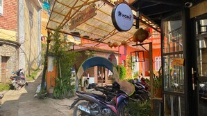 Una tienda de alquiler de motocicletas con un letrero que dice "HOME" y un letrero de "Dorm DHome" que indica un dormitorio.