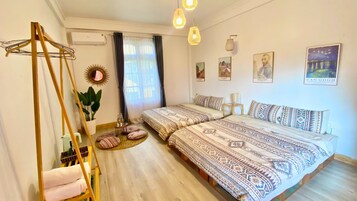 Un dormitorio con dos camas, una hamaca, un espejo y obras de arte en las paredes.
