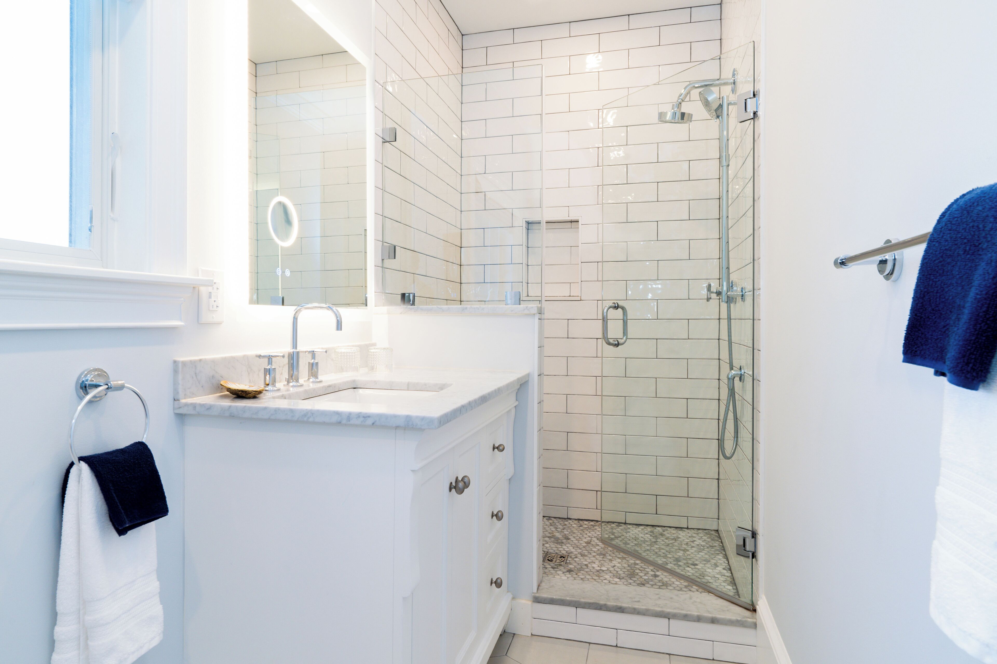 A modern bathroom with a shower, a sink, and a mirror.