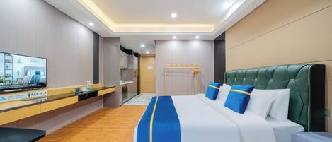A hotel room with a bed, a desk, a television, and a bathroom.