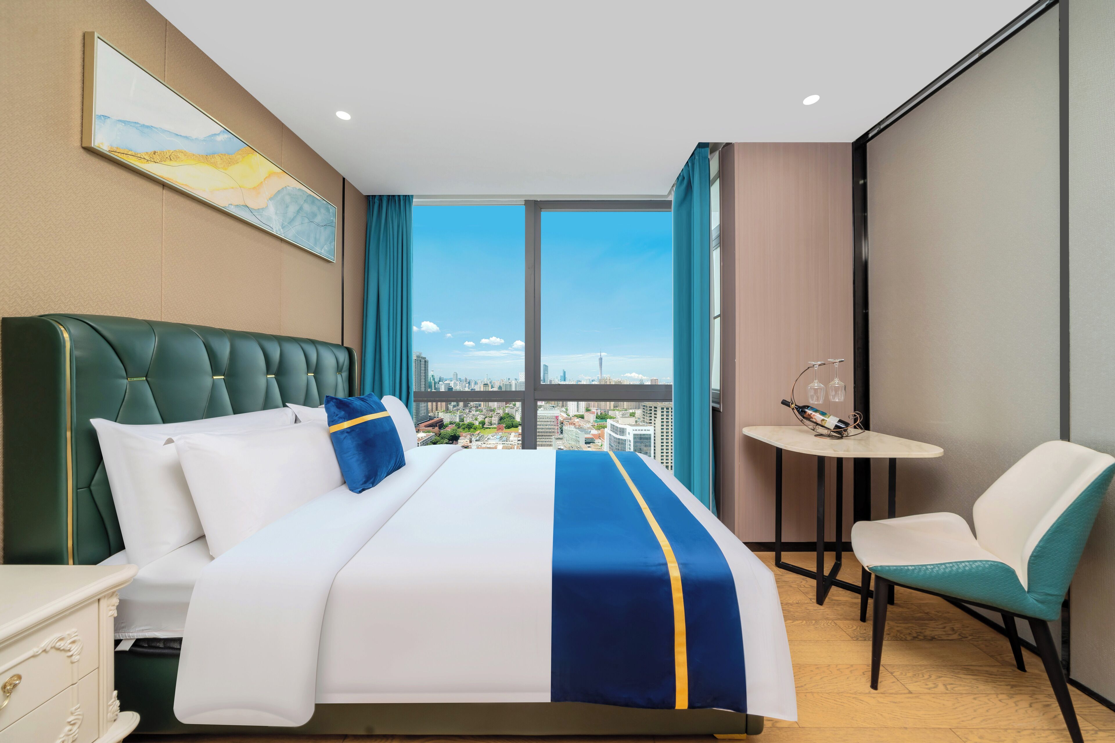 Habitación de hotel con una cama grande, vistas a la ciudad, una mesita y una silla.