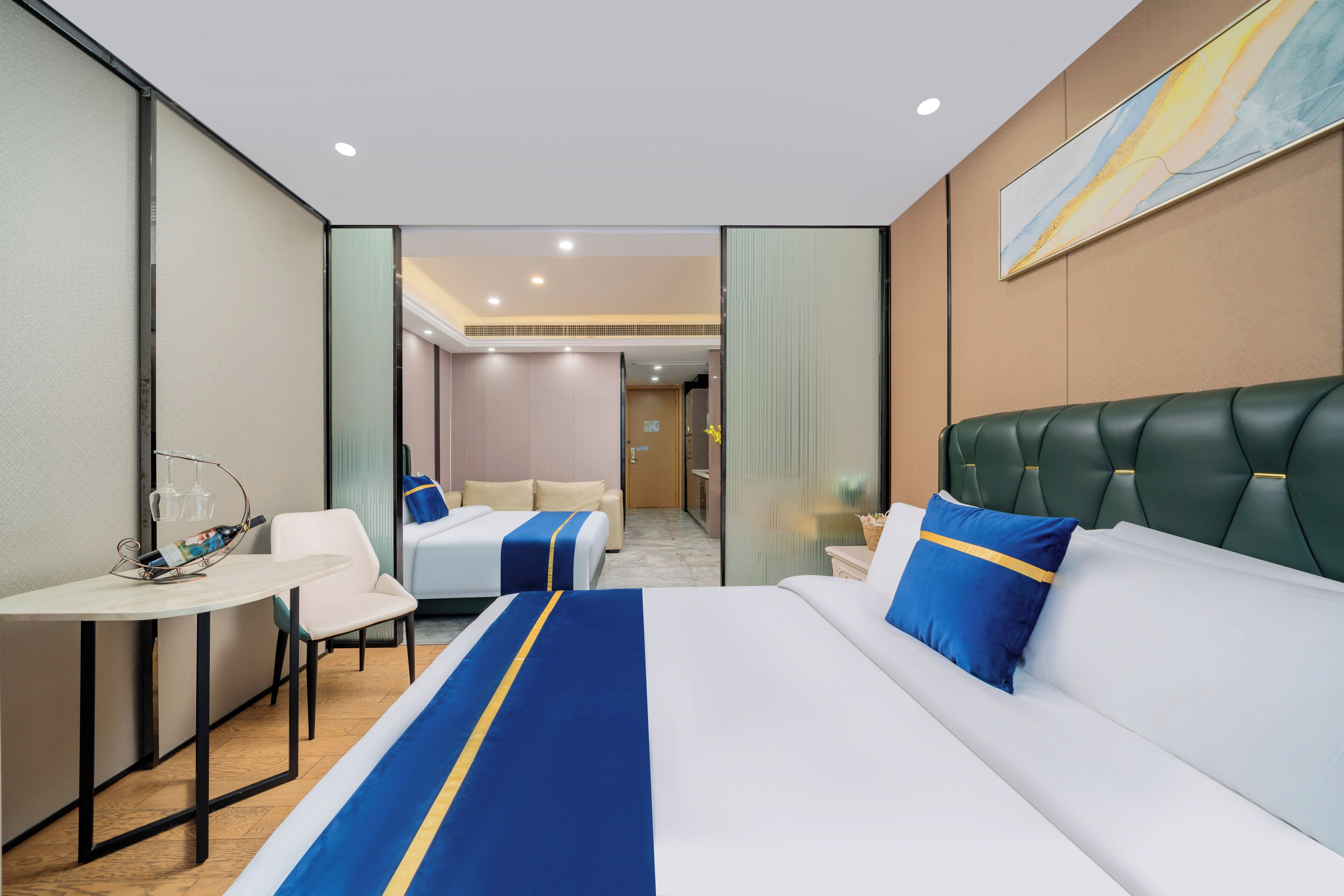 A hotel room with a large bed, a desk, and two smaller beds.