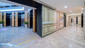 A modern lobby with elevators, potted plants, and a clean, polished floor. - Weekend International Apartment- Beijing Rd A-mall (Guangzhou)