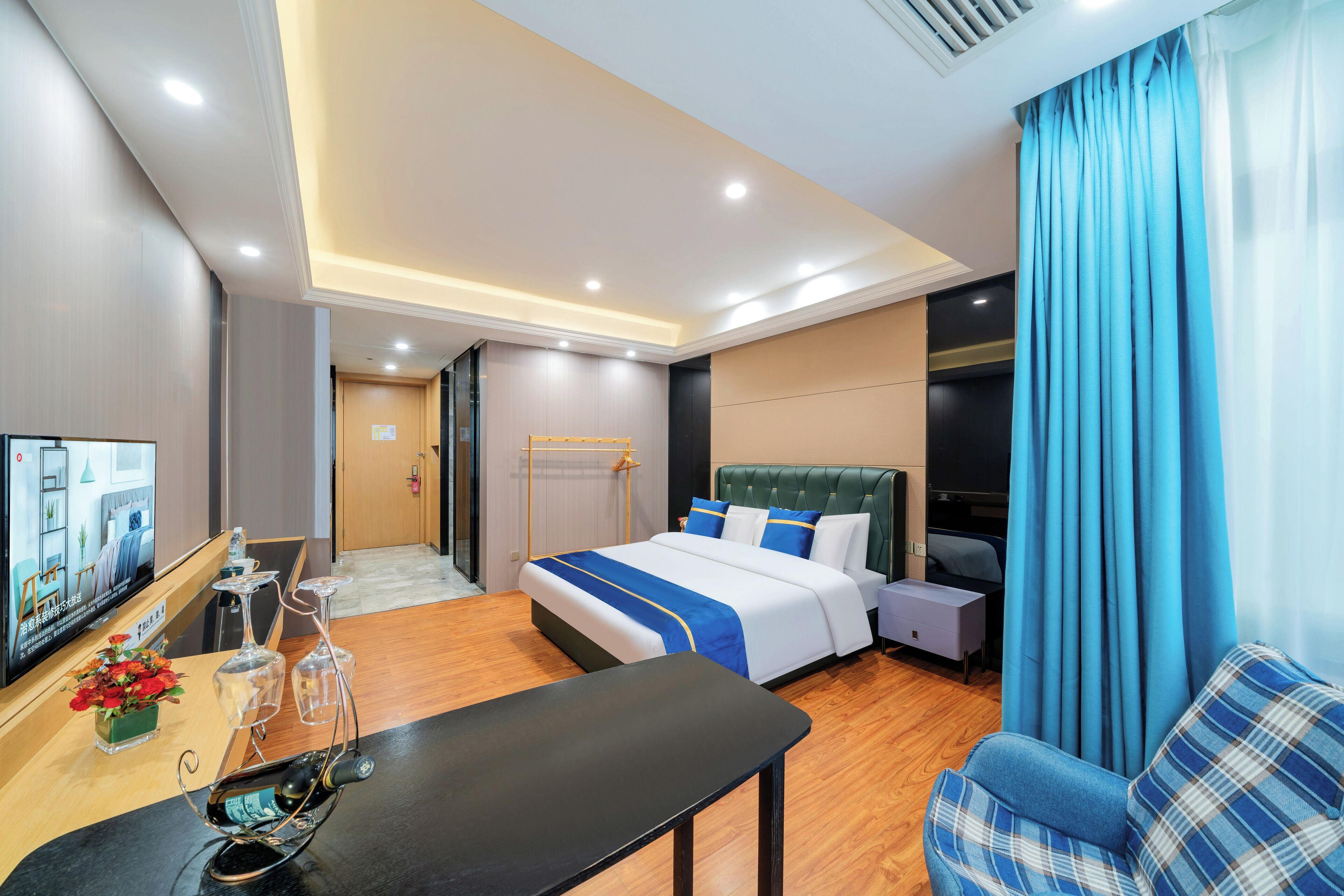 A hotel room with a bed, a TV, a desk, and a chair.